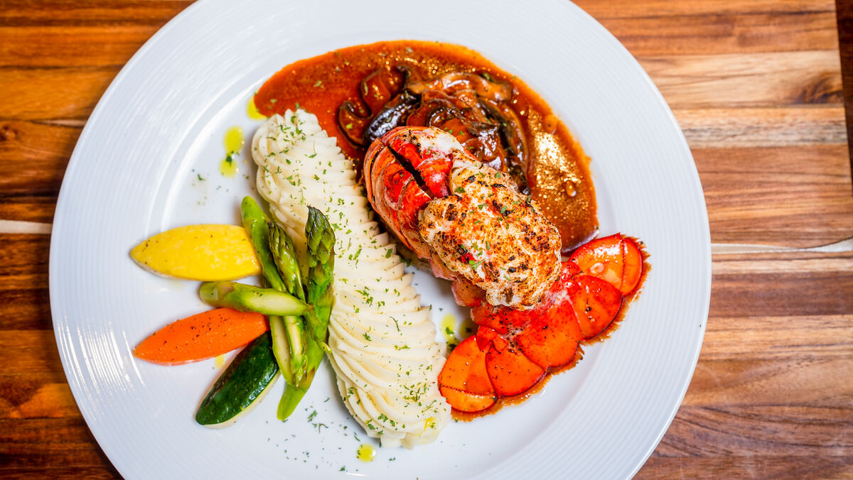 Lobster tail with vegetables and sauce, plated for a New York restaurant menu